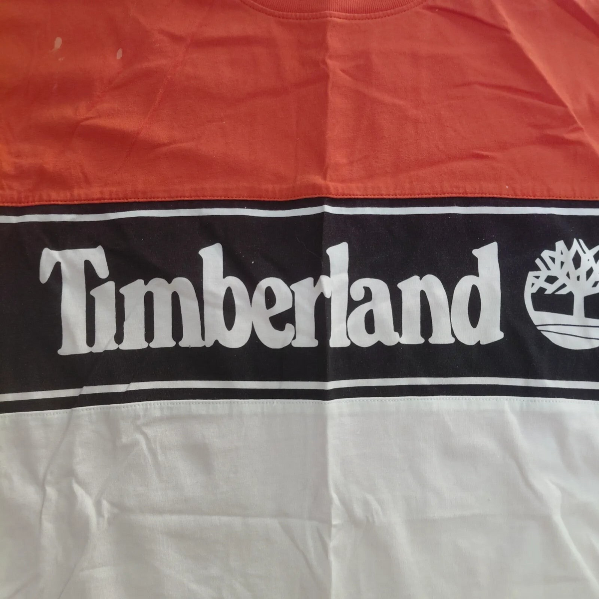 My Store Timberland organic cotton t-shirt featuring an orange, black, and white colour block logo design.