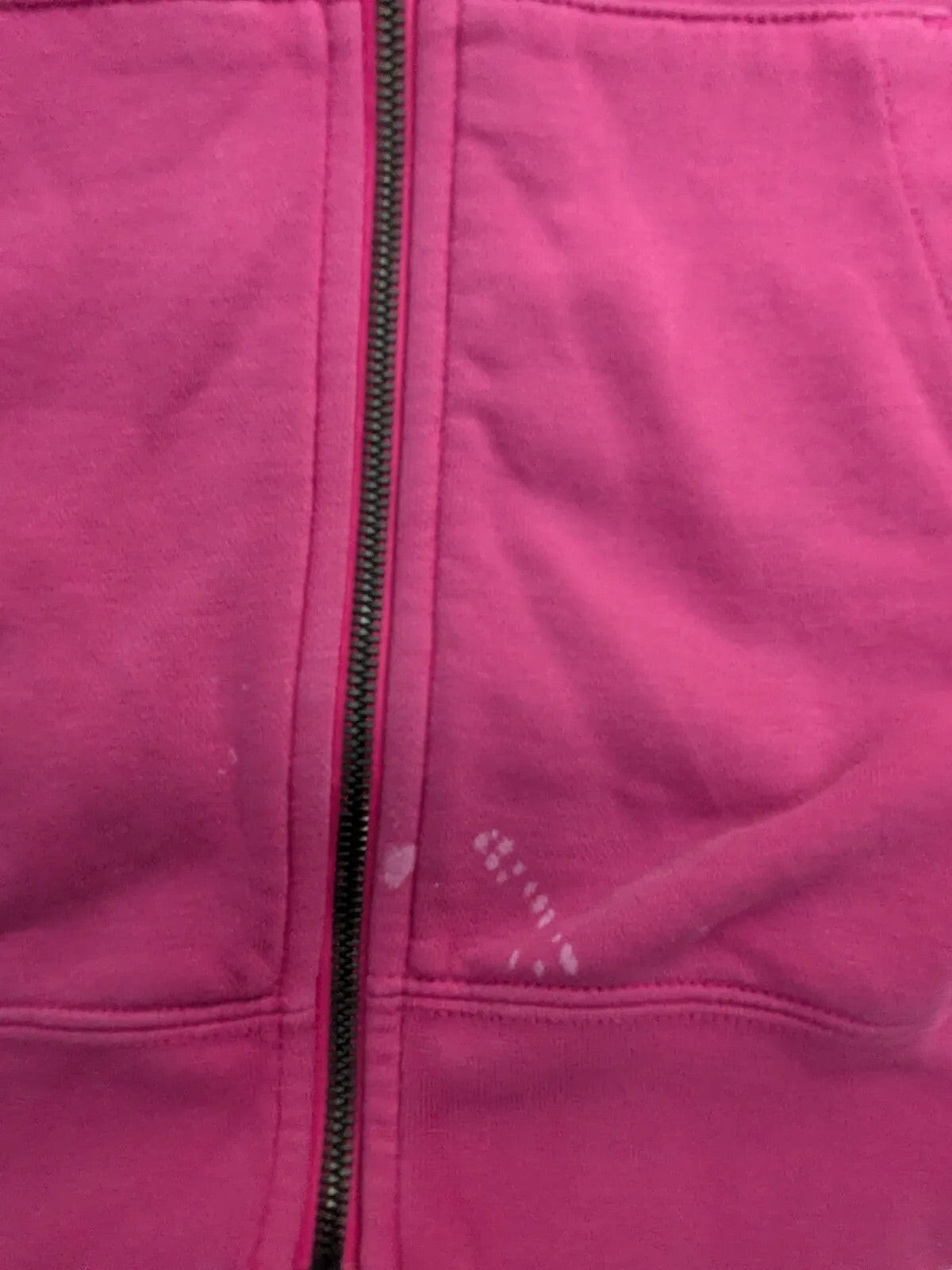 My Store pink Nike zip hoodie showing a small white stain near the metal zipper closure