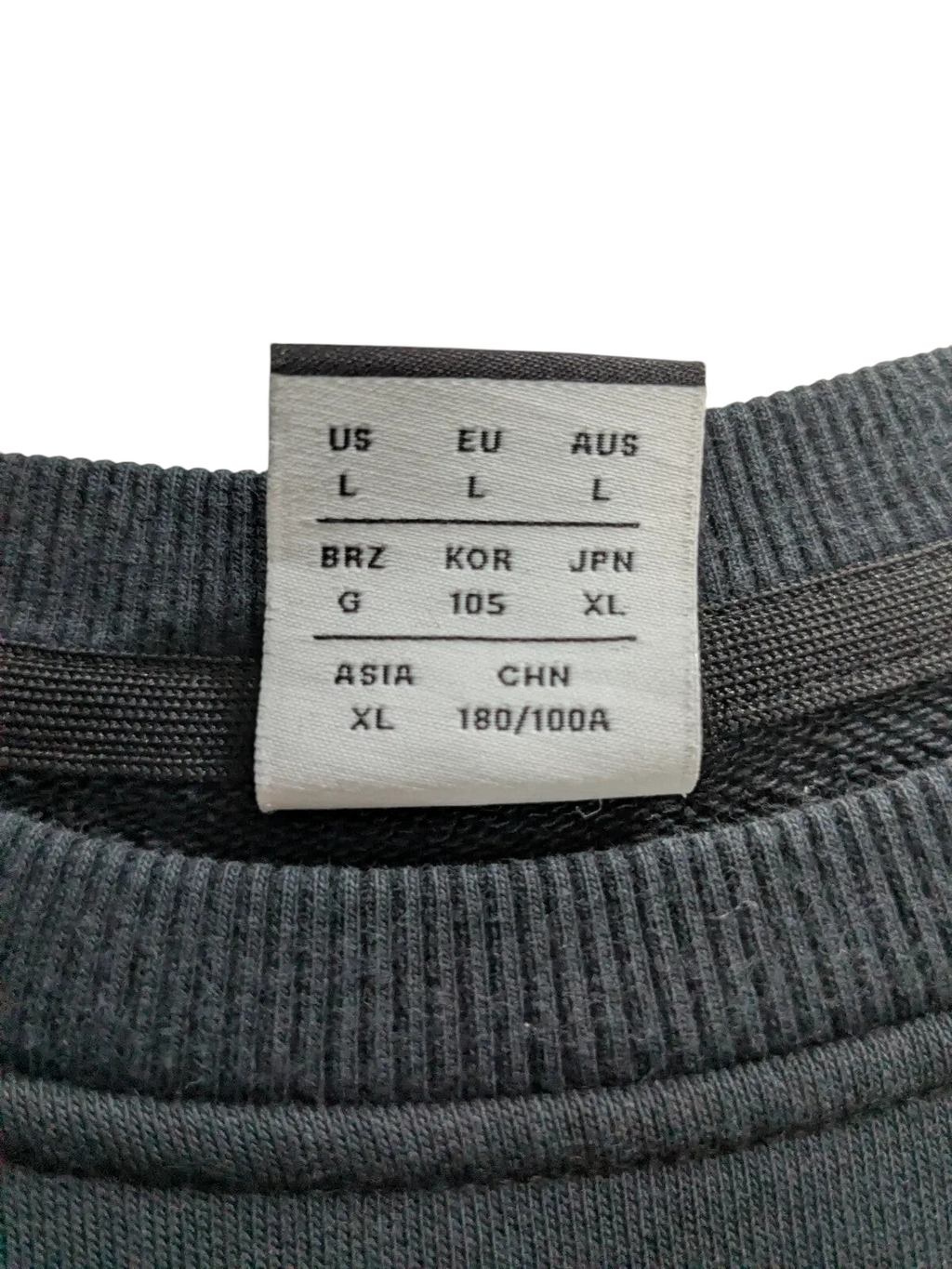 My Store New Balance crewneck sweatshirt size label showing international sizing standards on black fabric