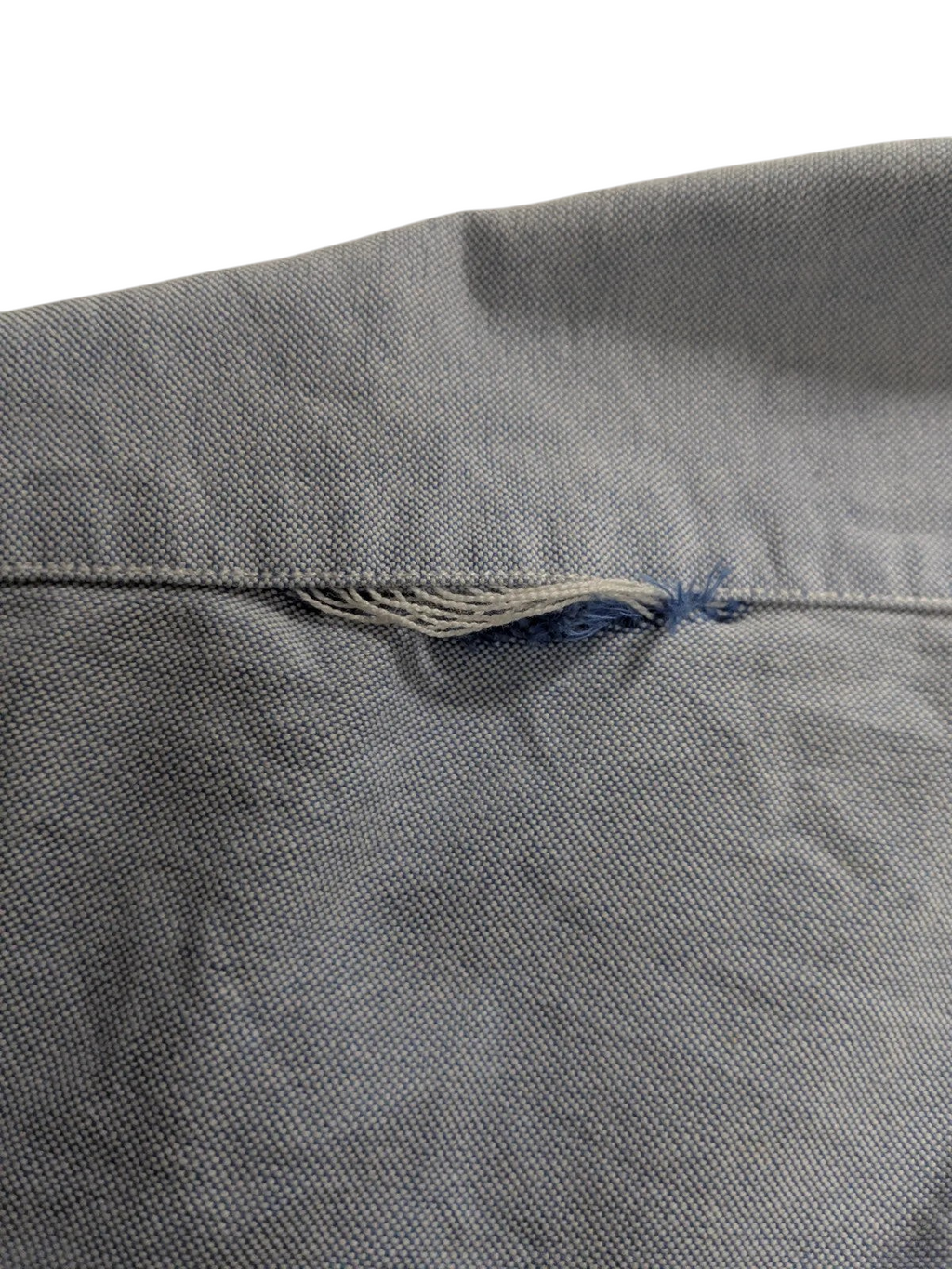 My Store Ralph Lauren light blue cotton shirt showing fraying damage on the fabric seam