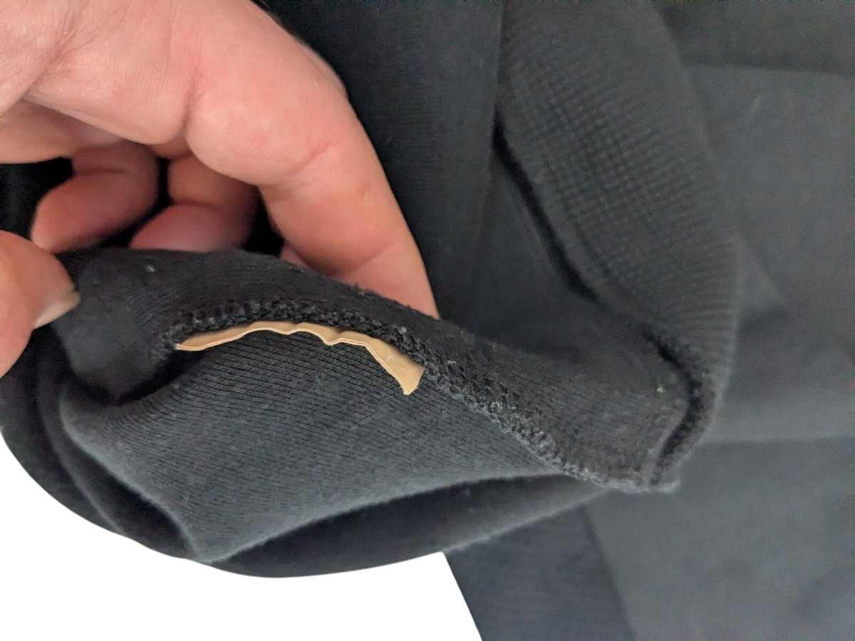 My Store EA7 Emporio Armani black track jacket showing a small fabric tear on the sleeve cuff