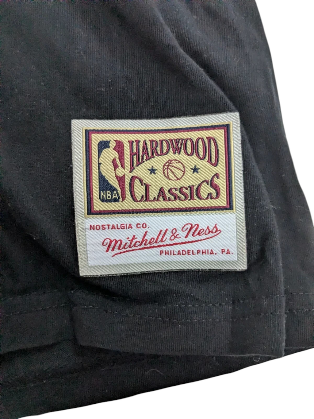 My Store Mitchell & Ness Hardwood Classics logo patch on a black cotton t-shirt